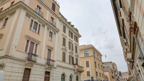 Eine enge Straße gesäumt von historischen Gebäuden mit klassischer Architektur, großen Fenstern und Balkonen.