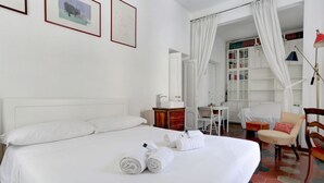 Ein Hotelzimmer mit einem großen Bett, einem Schreibtisch, einem Stuhl und einem Bücherregal.