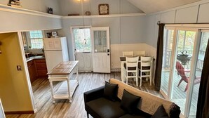 A compact living space with a kitchenette, a dining area, and a seating area with a sofa and chairs.
