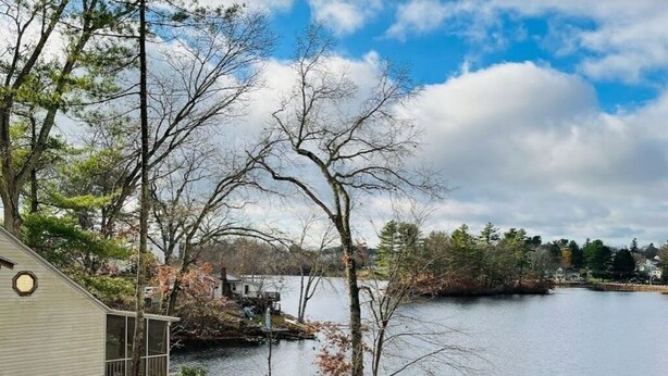 A lakeside property with a house, a dock, and a view of the water.