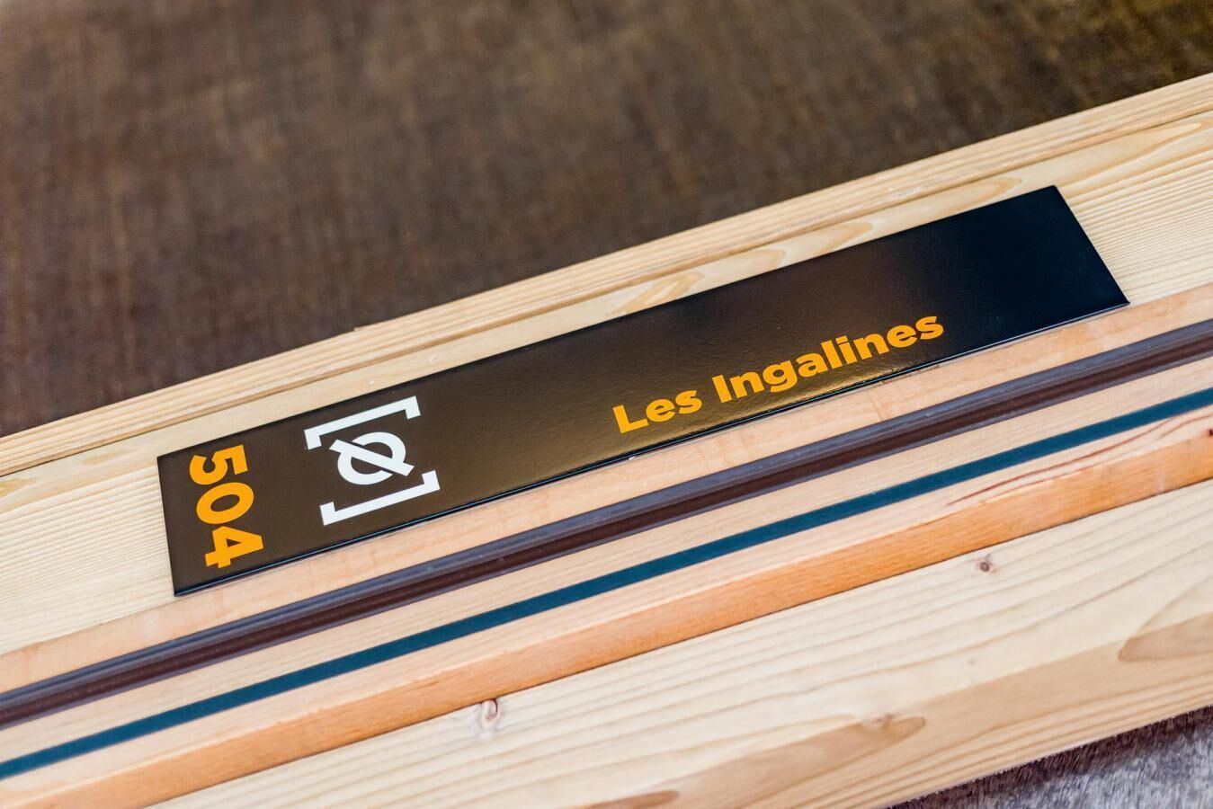 A wooden box with a black label that reads "504 Les Ingallines."