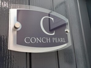 Een bord met de tekst 'CONCH PEARL' en een grote letter 'C'.