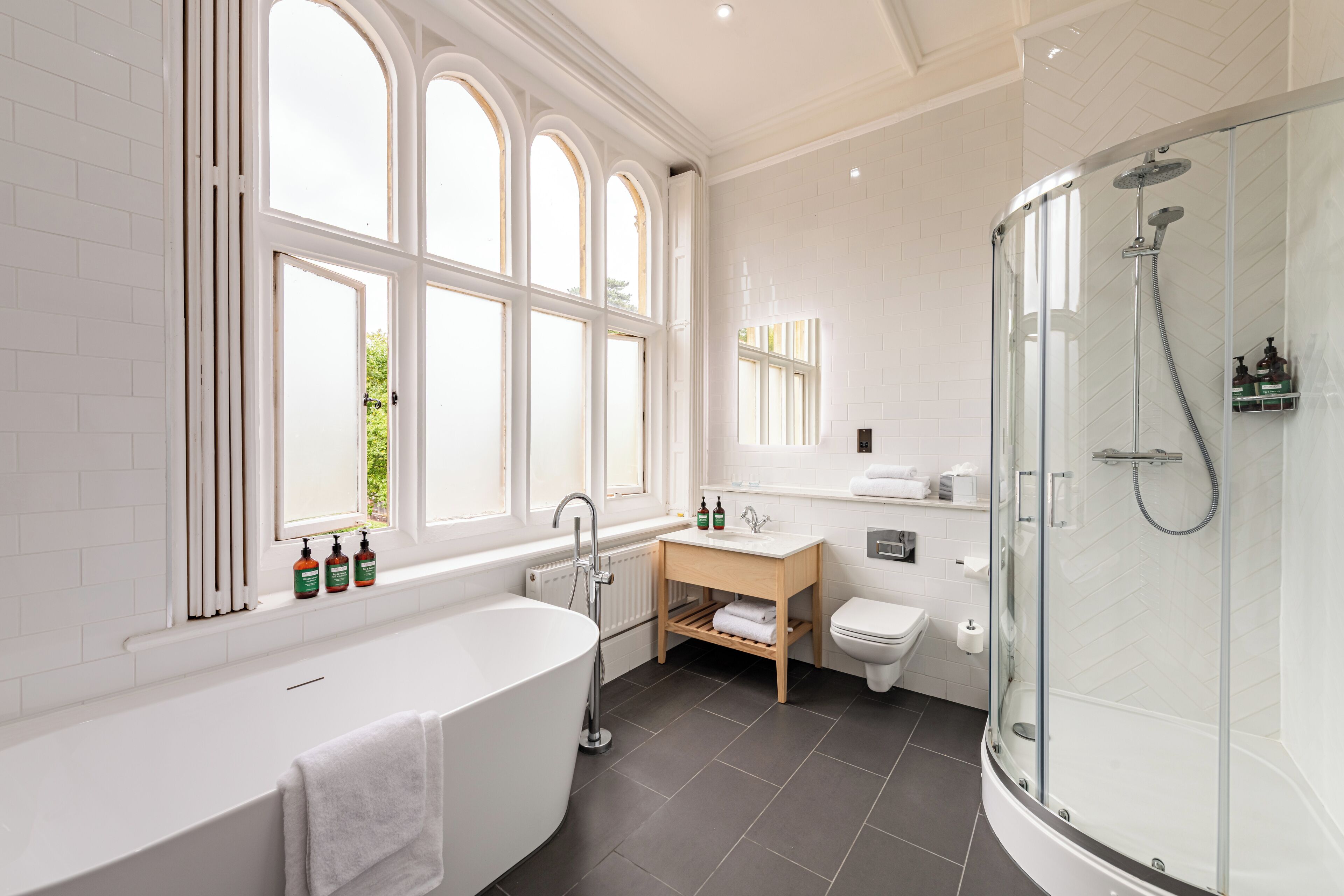 A modern bathroom with a freestanding bathtub, a glass-enclosed shower, and a toilet.
