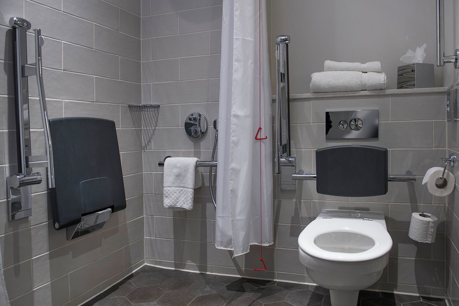 Un baño moderno con ducha, inodoro y toallero.