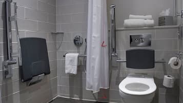 Un baño moderno con ducha, inodoro y toallero.