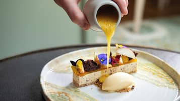 A dessert with a creamy topping being poured onto it.
