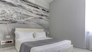 A modern bedroom with a bed, a nightstand, and a wall mural. - Voyager House Apartment (Roma)