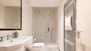 Un baño moderno con ducha, inodoro y lavamanos.