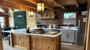 Eine rustikale Küche mit einer Holzinsel, einem Backsplash im Fischgrätmuster und einer grünen Wand.