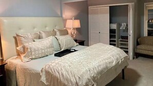 A bedroom with a bed, bedside table, lamp, and a wardrobe. - Southdale Stinger! Modern 5+BR near it all (Edina)
