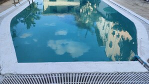 A rectangular swimming pool with a metal ladder on one side and a drainage grate at the bottom. - Thai smile serviced Appartments (Pattaya)