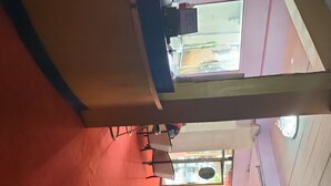 A room with a red carpet, a sofa, a glass partition, and a ceiling fan. - Thai smile serviced Appartments (Pattaya)