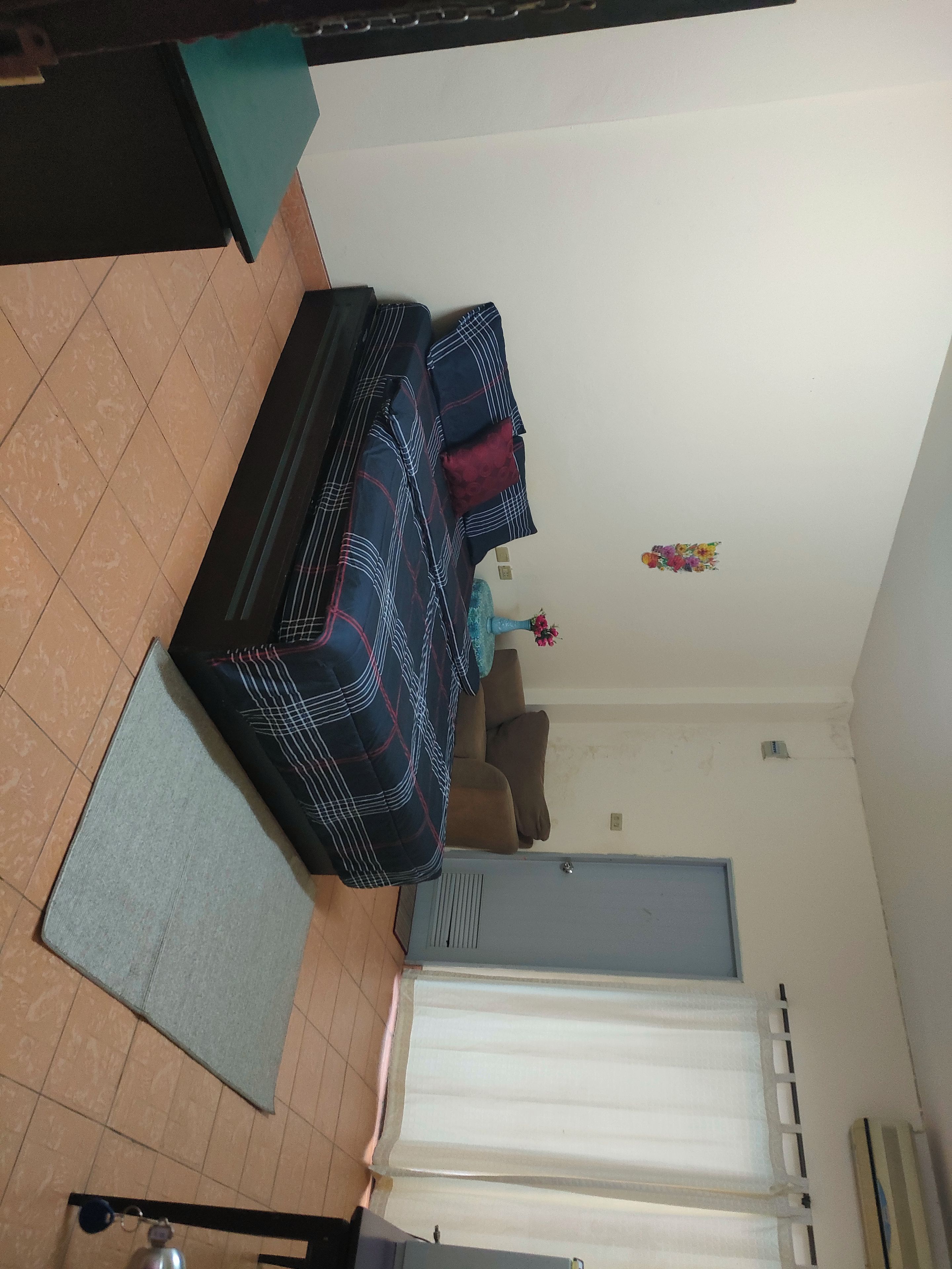 A living room with a sofa, a coffee table, and a door.