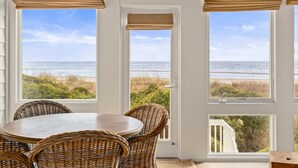 A room with a view of the ocean, wicker furniture, and a ceiling fan. - Beach Club Villa 30 - Oceanfront! Pool! Walkout! (Isle of Palms)