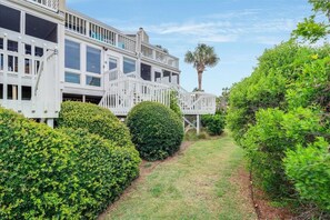 Stylish two-story home with a modern design, featuring a well-manicured lawn and a spacious deck.