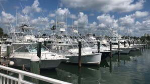 A marina with multiple boats docked at wooden piers.