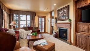 A cozy living room with a fireplace, leather furniture, and a television. - Outpost: Grand View 491A (Jackson)
