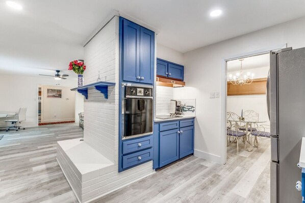 Eine moderne Küche mit blauen Schränken, einem Einbauofen und einem Kühlschrank.