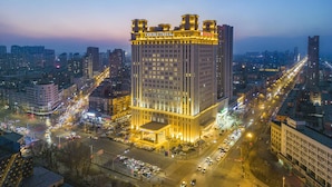 A high-rise hotel with a prominent entrance, multiple floors, and a busy urban street below. - Doubletree By Hilton Anshan (Anshan)