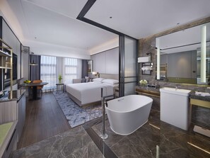 A modern hotel room with a large bed, a separate bathroom with a bathtub, a vanity with a mirror, and a seating area with a table and chairs. - Doubletree By Hilton Anshan (Anshan)