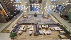 A spacious lobby with multiple seating areas, a large chandelier, and a mural on the wall. - Doubletree By Hilton Anshan (Anshan)