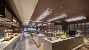 A modern hotel lobby with a central reception desk, a buffet area, and a seating area with a view of the cityscape. - Doubletree By Hilton Anshan (Anshan)