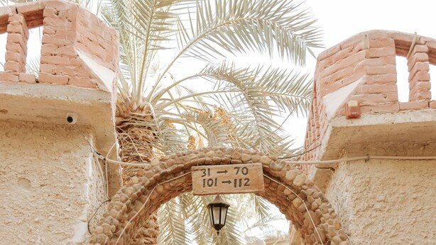 Un arco de piedra con un cartel que indica las direcciones.