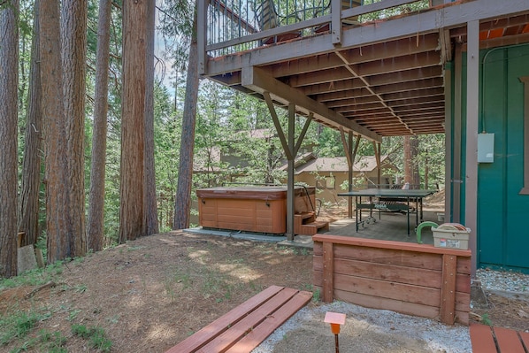 A rustic cabin with a wooden deck, a hot tub, and a table. - PRIVATE HOT TUB + ACCESS TO BLS RECREATION CENTER (Arnold)