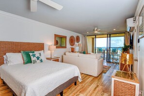Une chambre spacieuse avec un grand lit, un canapé et un balcon offrant une vue agréable.