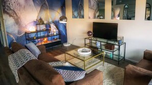 Een moderne woonkamer met een bank, salontafel en een televisie.