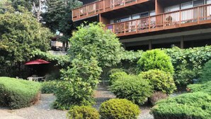 A courtyard with neatly trimmed bushes and a gravel path.