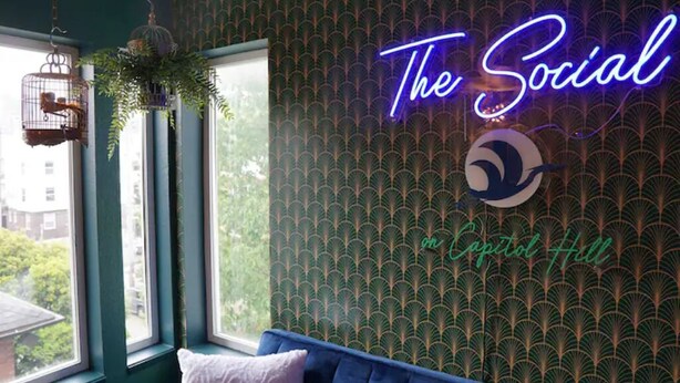 A room with a neon sign reading "The Social" and "on Capitol Hill". - Stylish 2 Bedroom Capitol Hill Apartment (Seattle)