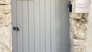 Una puerta con picaporte metálico y un buzón.