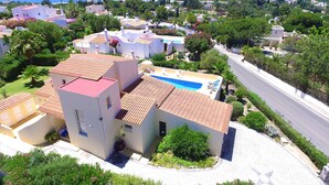 A residential area with a swimming pool, white buildings, and a view of the sea. - Heatable pool & BBQ retreat in Carvoeiro (Carvoeiro)