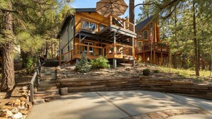 A two-story log cabin with a deck and a covered outdoor area. - Monterey Log Lair With Pool Table - Slope Views (Big Bear Lake)