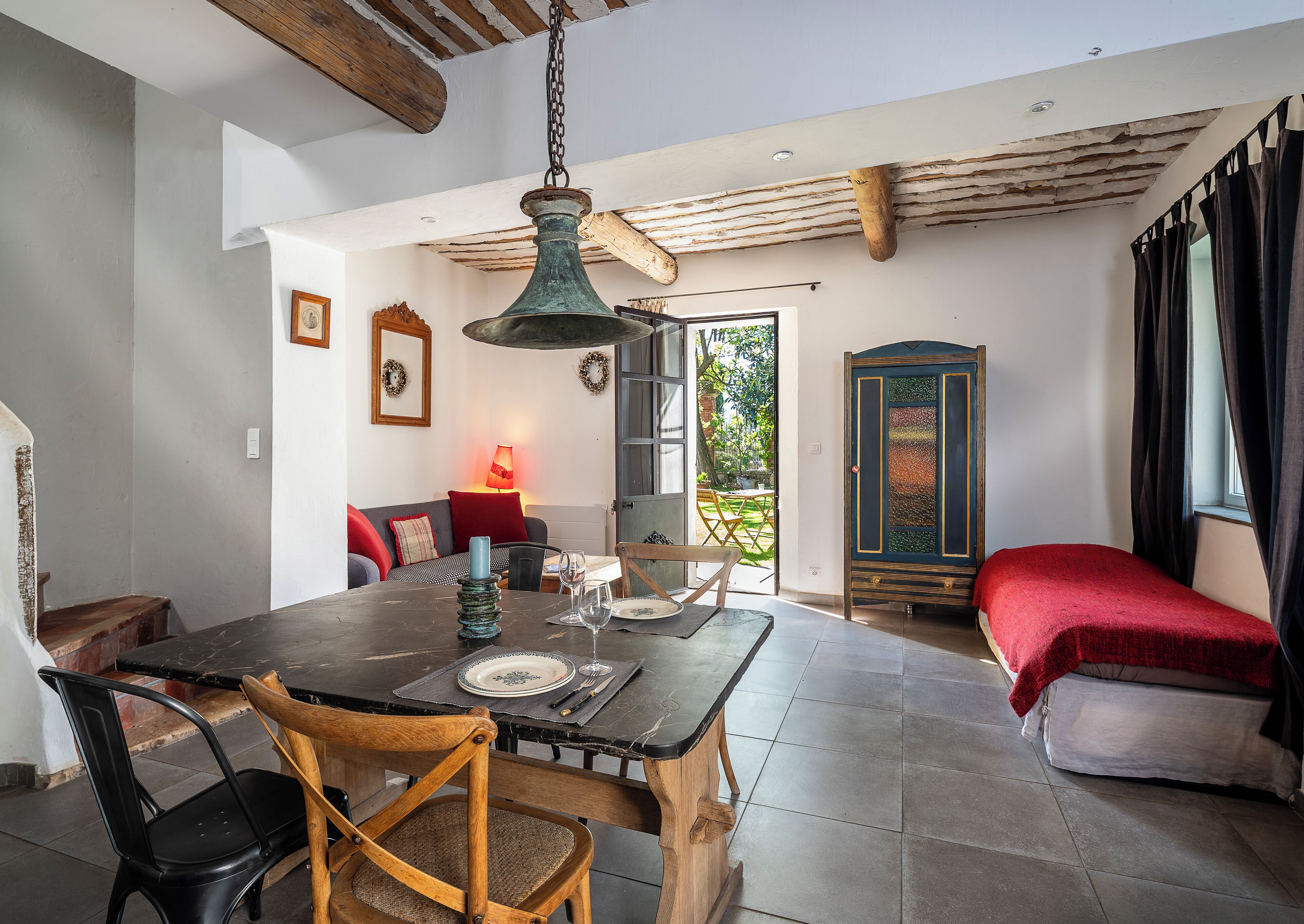 A dining area with a wooden table, chairs, and a hanging light fixture.