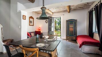 A dining area with a wooden table, chairs, and a hanging light fixture.