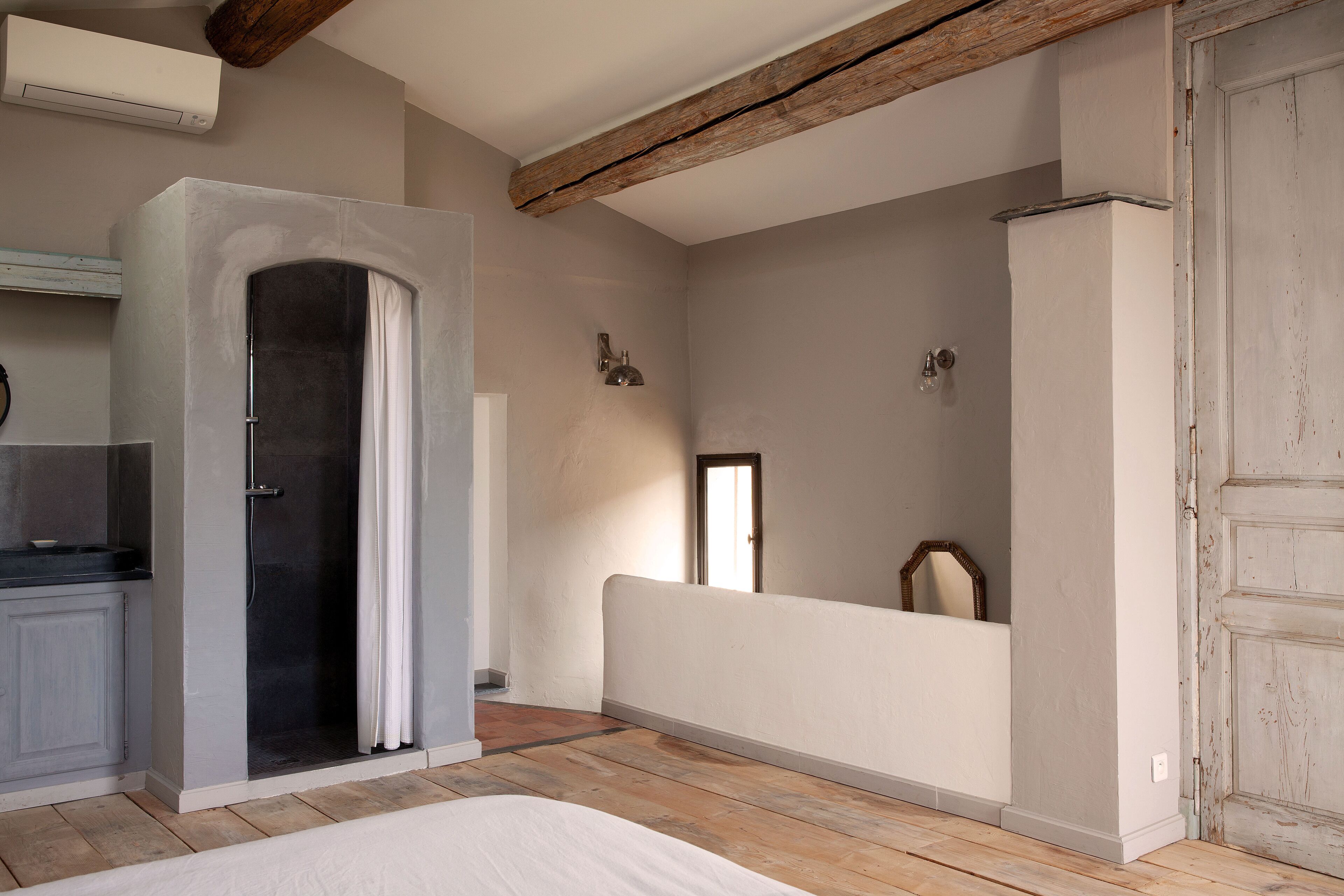 A room with a shower, a mirror, and a door.