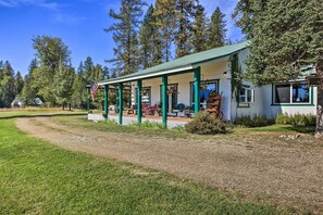 Mökki, jossa on kuisti ja joka sijaitsee metsän ympäröimänä.