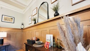 A wooden console table with various items including a bowl, bottles, and a lamp. - Historic GG Barnum Mansion by Heirloom Boutique Collection (Duluth)