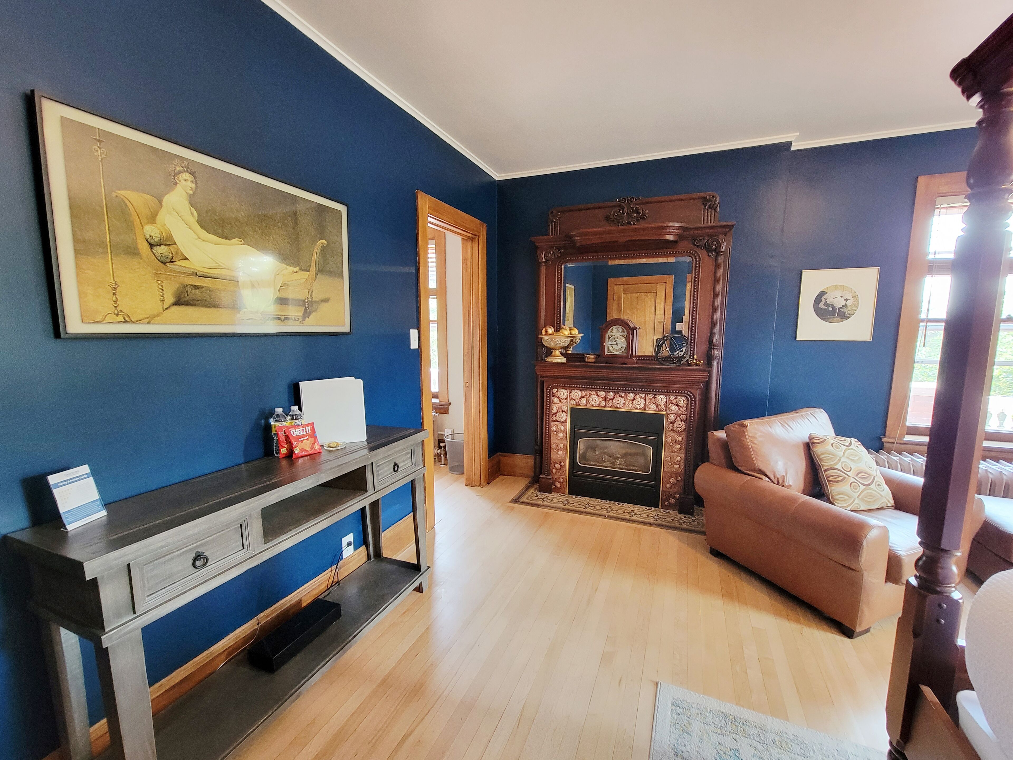 A living room with a fireplace, a sofa, a coffee table, and a painting on the wall.