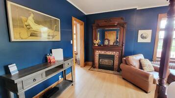 A living room with a fireplace, a sofa, a coffee table, and a painting on the wall.