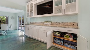 A modern kitchen with white cabinets, a granite countertop, and a built-in microwave. - Heated Pool I Soundproof Home I Firepit I 630Mbps (Hollywood)