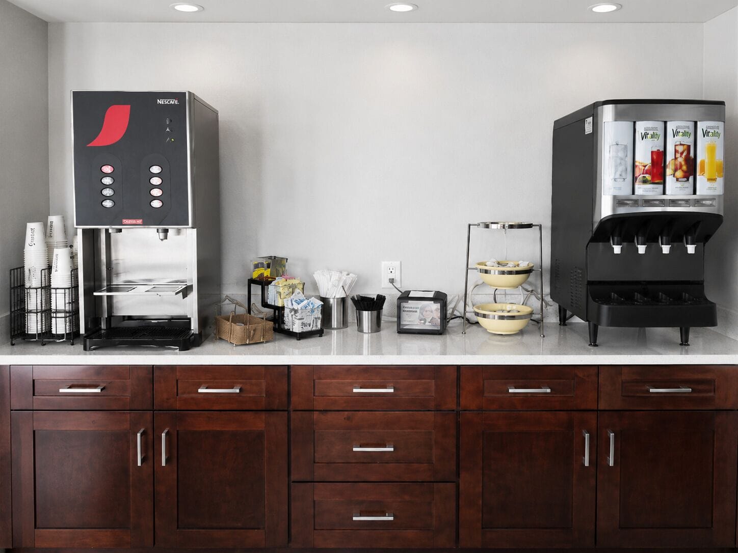 Une petite cuisine équipée d’une machine à café Nescafé, d’un distributeur d’eau et d’un grille-pain.