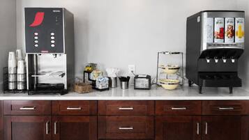Une petite cuisine équipée d’une machine à café Nescafé, d’un distributeur d’eau et d’un grille-pain.