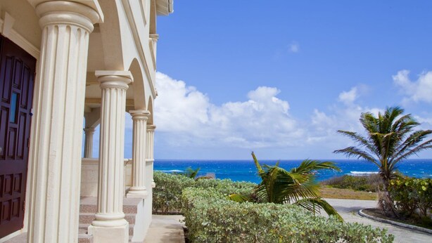A building with white columns and a view of the ocean.
