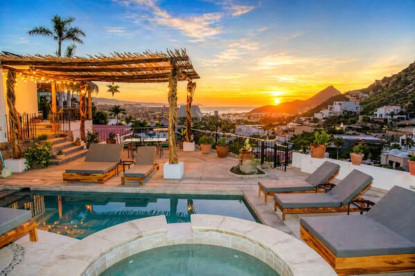 A rooftop pool area with lounge chairs, a hot tub, and a pergola with string lights. - Walk to Marina Town & Beach. Stunning Views. Pickleball & Tennis court community (Cabo San Lucas)