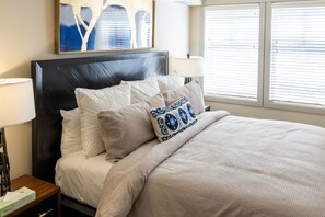 Relax in comfort with a large bed, bedside table, and decorative art.