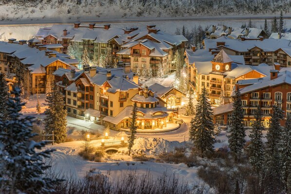 Experience the charm of a traditional resort with wooden facades and pitched roofs, set amidst snow-covered grounds.