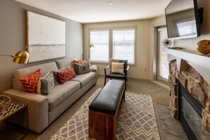 Relax in this stylish living room with a sofa, armchair, and patterned rug.